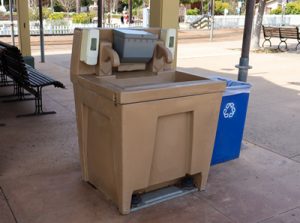 portable hand washing station next to a bench
